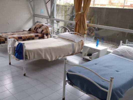 una stanza in cui si vedono tre letti singoli rifatti