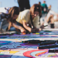 Bambini che colorano la strada con i gessetti